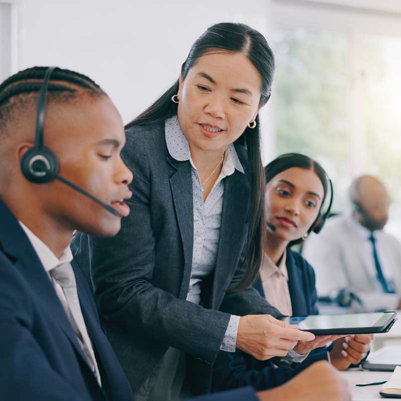 female customer service manager coaches an agent using a tablet