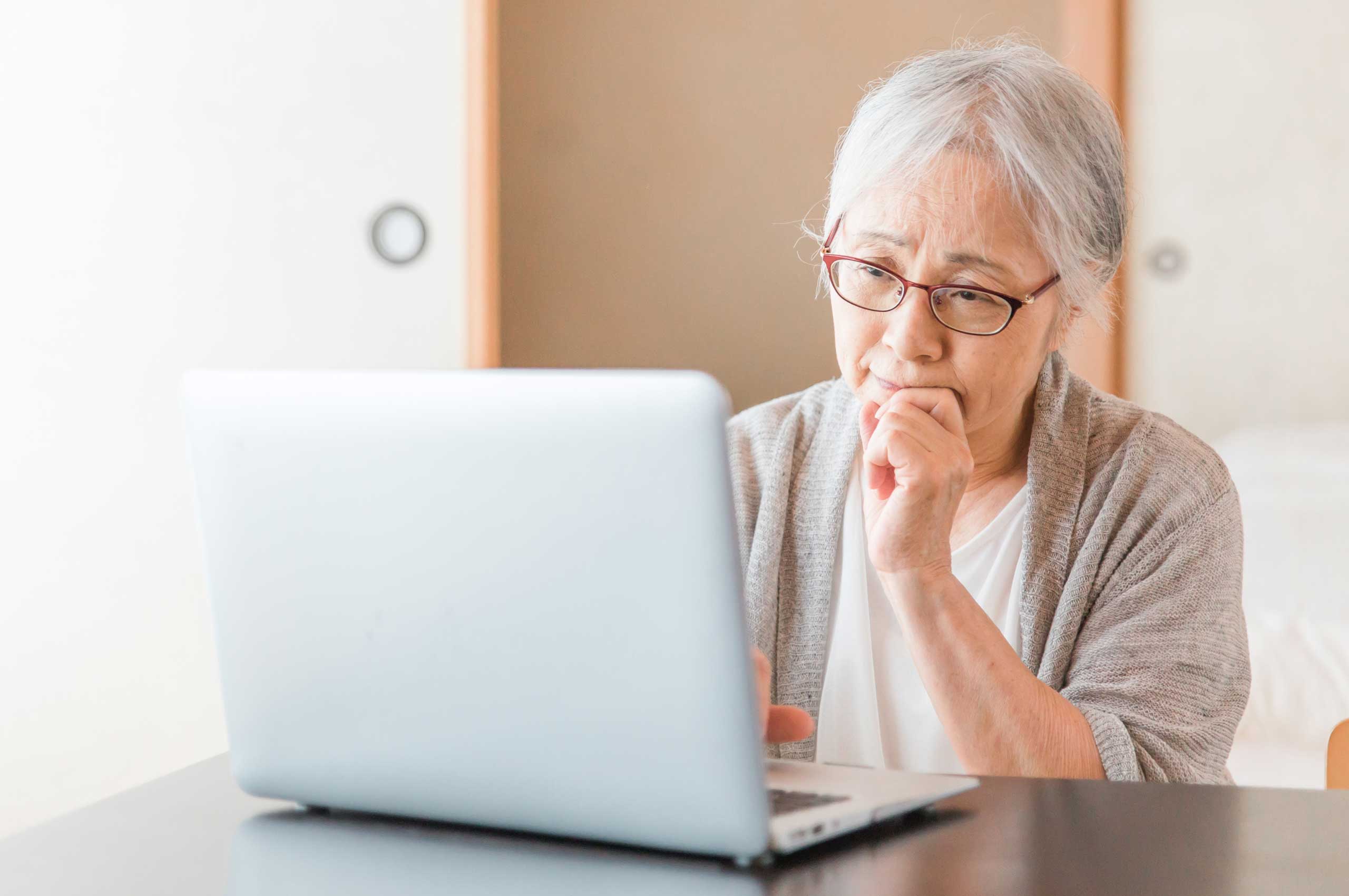 Elderly woman using a laptop to check email