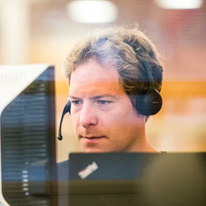 Man wearing a headset working at a customer service call center