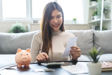 Young Asian Woman using a calculator to budget finances