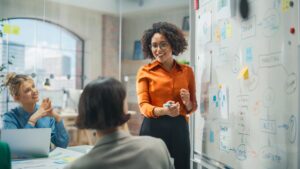 Black Female Executive Presents at a whiteboard to a Group