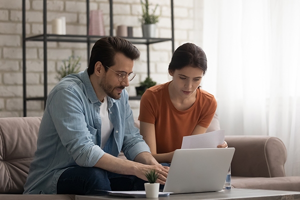 Two person checking data on their laptop